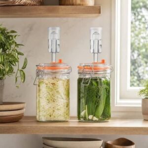 Twee glazen potten met groenten en fermentatiesloten op een keukenplank