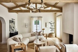 Warm minimalistische woonkamer met houten balken, zachte sofa en natuurlijke materialen