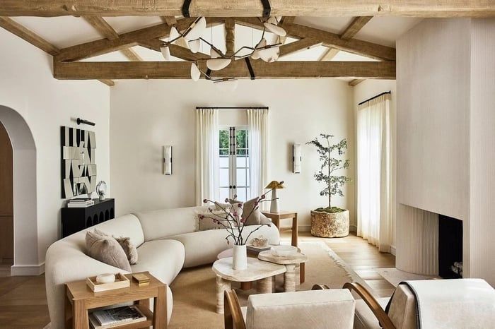 Warm minimalistische woonkamer met houten balken, zachte sofa en natuurlijke materialen